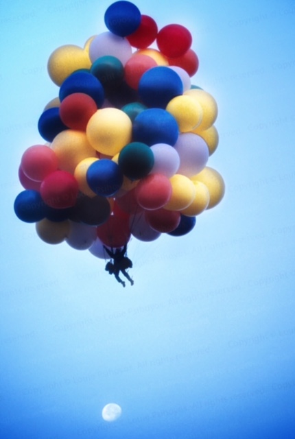 man floating away on balloons